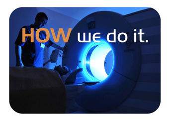 Image of participant in darkened scanner next to researcher